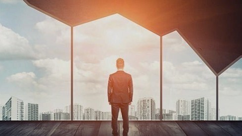 Businessman looking out window shaped like a bar graph